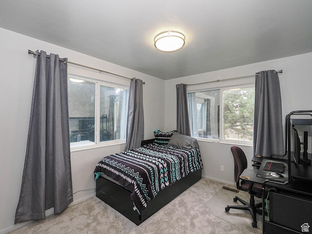 bedroom featuring carpet, baseboards, and an office area