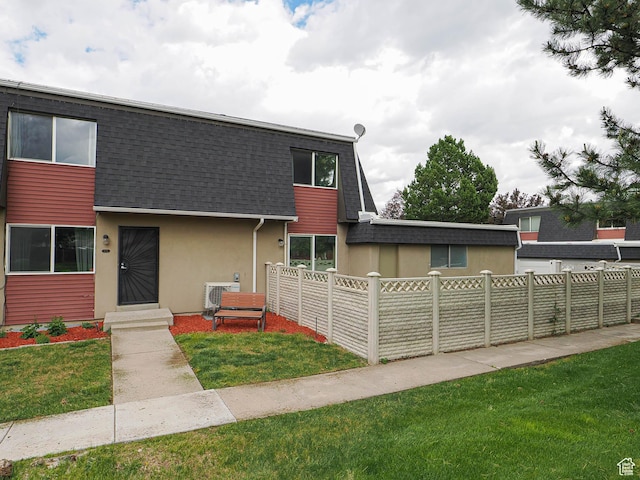 view of front of home featuring roof with shingles, stucco siding, and mansard roof