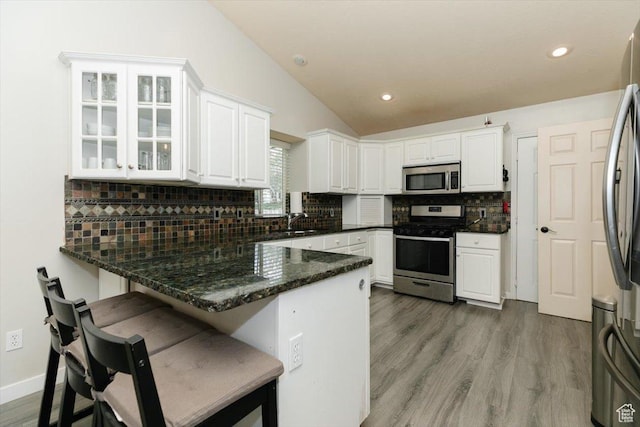 375 S 900 E, Smithfield, UT 84335 - kitchen featuring appliances with stainless steel finishes, a peninsula, vaulted ceiling, white cabinetry, and a sink