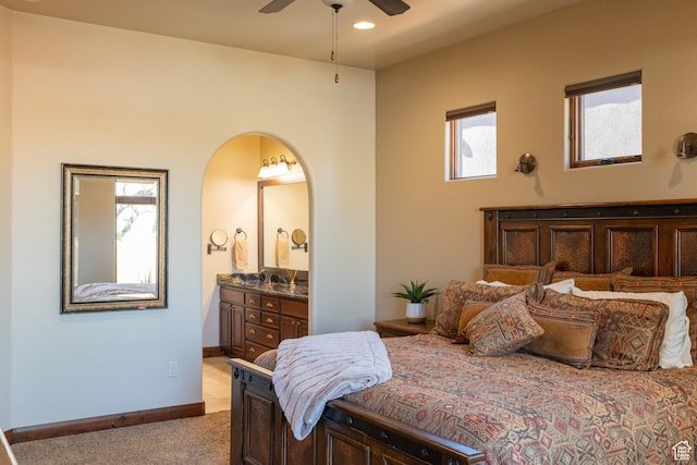 2090 N Tuweap Dr Unit 15, St George, UT 84770 - bedroom with light colored carpet, ensuite bath, arched walkways, recessed lighting, and baseboards