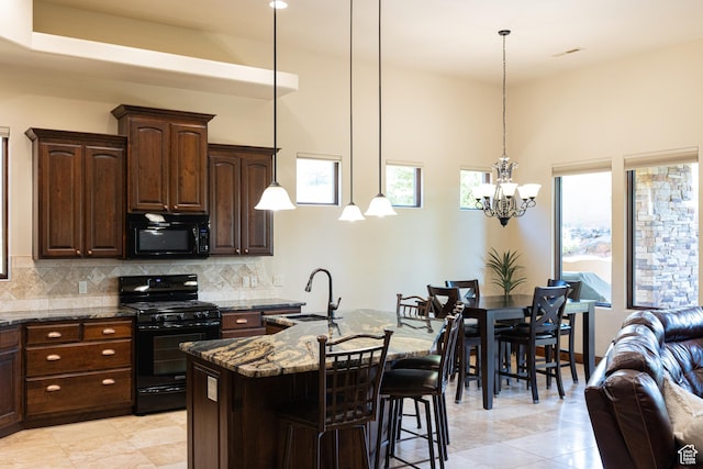 2090 N Tuweap Dr Unit 15, St George, UT 84770 - kitchen featuring black appliances, dark stone countertops, a sink, backsplash, and a towering ceiling