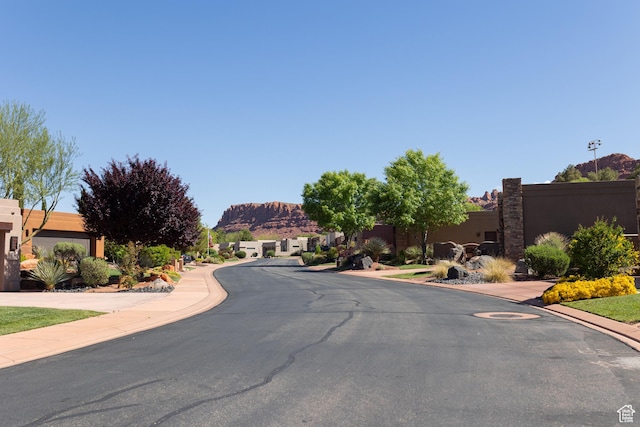 2090 N Tuweap Dr Unit 15, St George, UT 84770 - view of asphalt road with a mountain view, sidewalks, and curbs