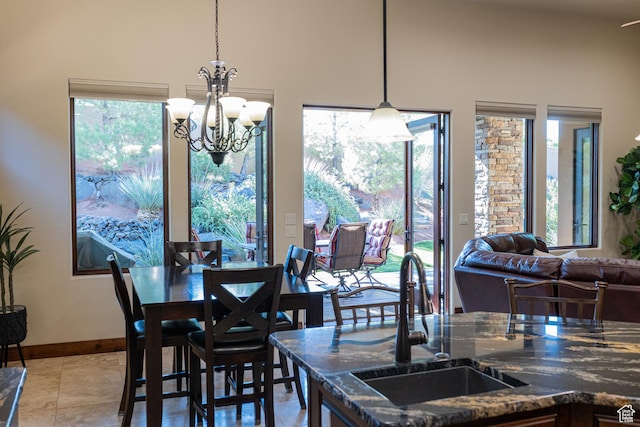 2090 N Tuweap Dr Unit 15, St George, UT 84770 - dining space featuring a chandelier, a high ceiling, baseboards, and light tile patterned floors