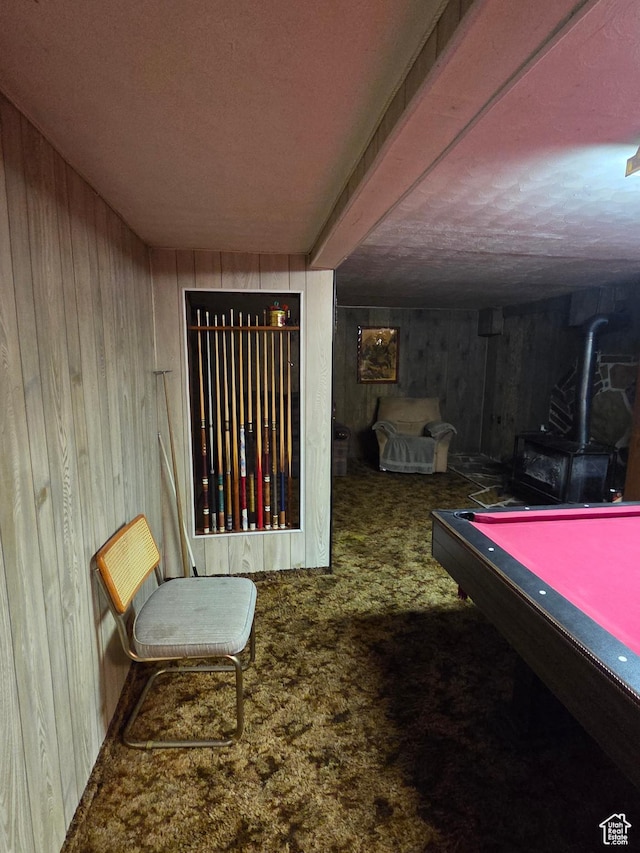 157 E 100 N, Wellington, UT 84542 - recreation room with a wood stove, wooden walls, carpet flooring, and a textured ceiling