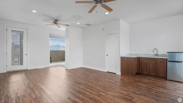 4955 W Daybreak Pkwy, South Jordan, UT 84009 - unfurnished living room featuring ceiling fan, dark wood-type flooring, recessed lighting, baseboards, and a sink