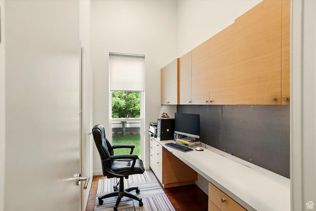 office space with dark wood-type flooring and built in study area