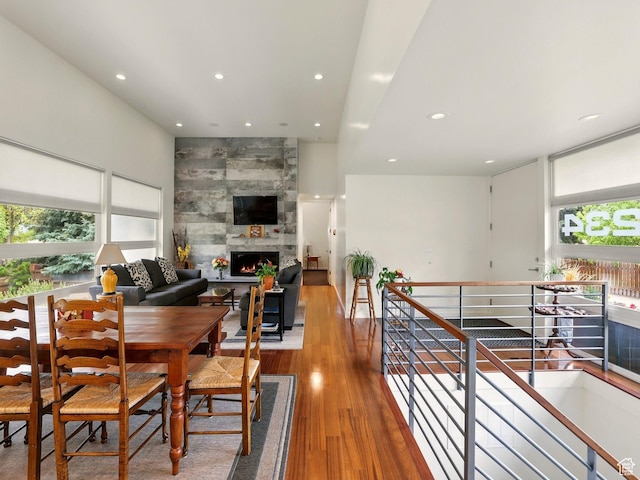 dining room featuring recessed lighting, wood finished floors, and a tile fireplace
