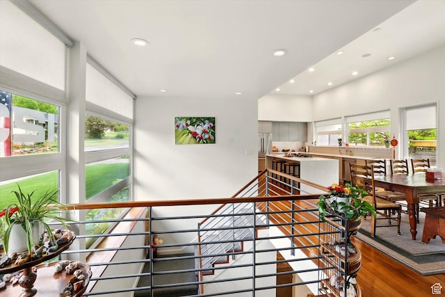 hall with recessed lighting, an upstairs landing, and wood finished floors