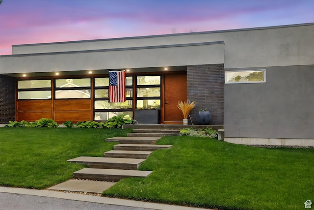 exterior entry at dusk with a yard