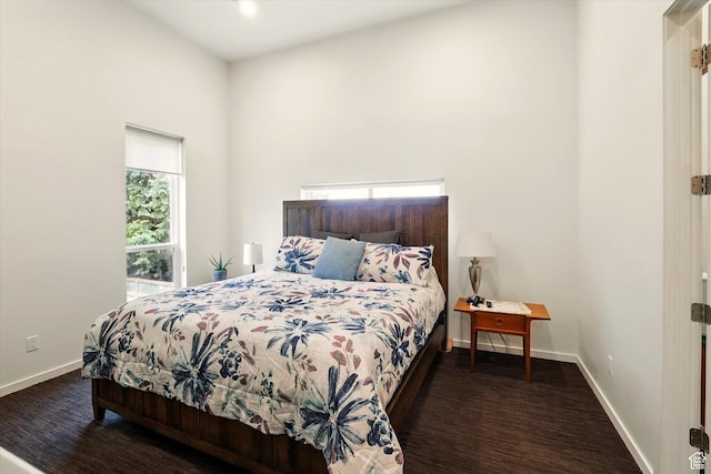 bedroom with baseboards and a high ceiling