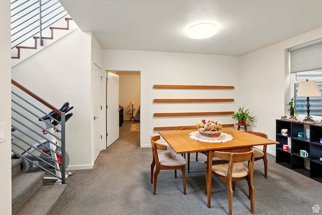 carpeted dining area featuring stairs and baseboards