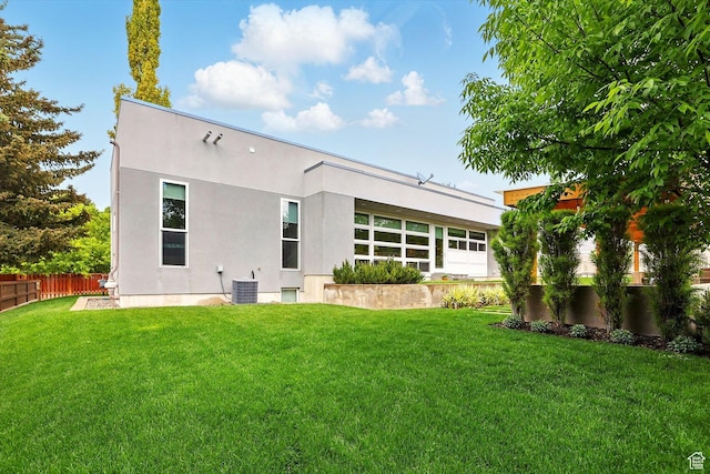 back of house featuring stucco siding and central AC