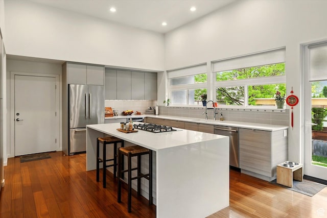 kitchen featuring appliances with stainless steel finishes, gray cabinetry, modern cabinets, a sink, and recessed lighting