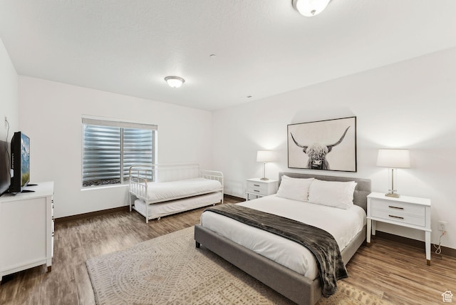 bedroom with baseboards and wood finished floors