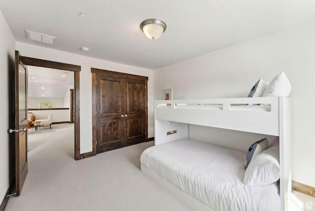 bedroom featuring light carpet and baseboards