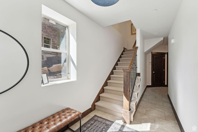 stairway featuring baseboards and tile patterned floors