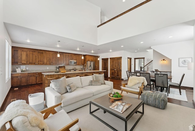 living area featuring recessed lighting, dark wood finished floors, healthy amount of natural light, and baseboards