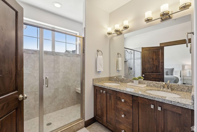 ensuite bathroom featuring a shower stall and double vanity