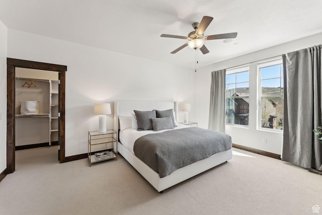 bedroom with carpet floors, baseboards, a spacious closet, and ceiling fan