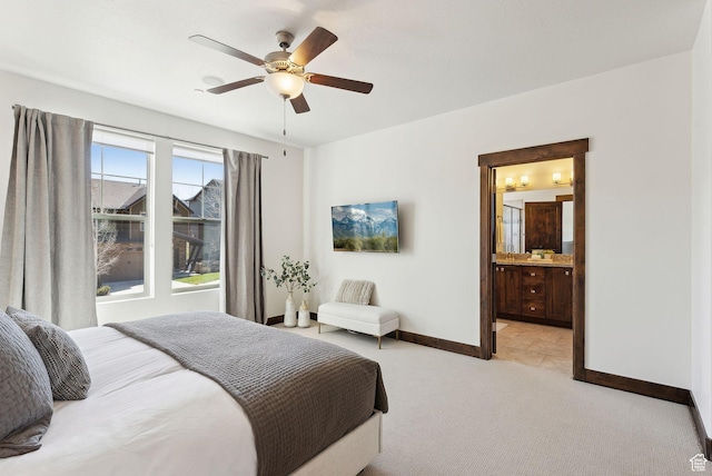 bedroom featuring baseboards, light colored carpet, a ceiling fan, and connected bathroom