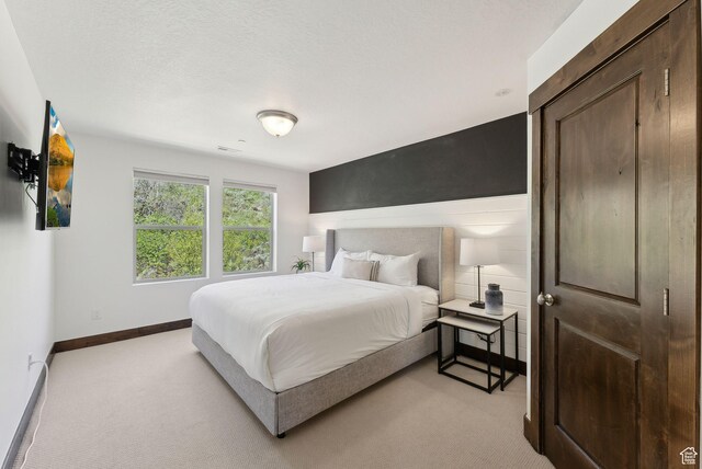 bedroom featuring light carpet and baseboards