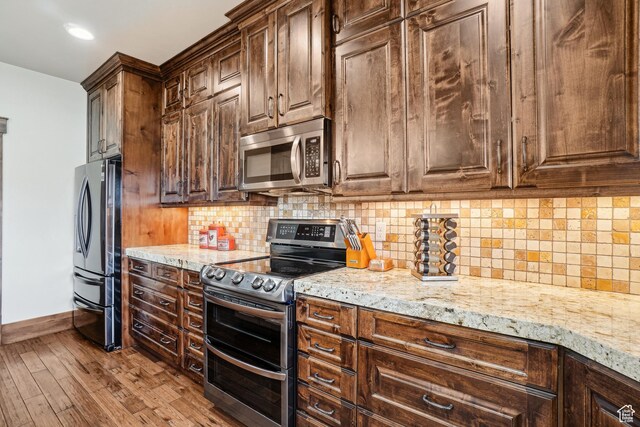 1236 S 2240 E, Heber City, UT 84032 - kitchen featuring appliances with stainless steel finishes, baseboards, light stone countertops, wood finished floors, and backsplash