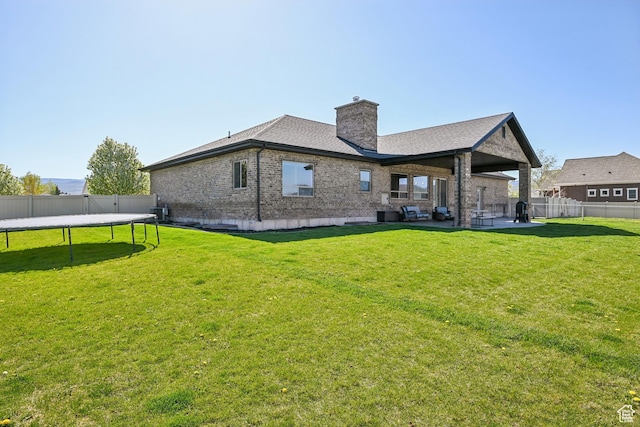 1236 S 2240 E, Heber City, UT 84032 - rear view of house with a trampoline, brick siding, a chimney, a patio, and roof with shingles