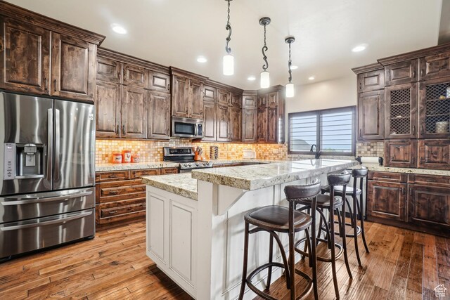 1236 S 2240 E, Heber City, UT 84032 - kitchen featuring appliances with stainless steel finishes, a center island, hardwood / wood-style floors, tasteful backsplash, and recessed lighting
