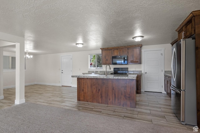 6594 S 1300 W, Taylorsville, UT 84123 - kitchen with black appliances, a chandelier, a kitchen island with sink, baseboards, and light wood finished floors