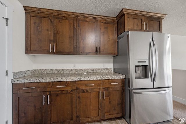 6594 S 1300 W, Taylorsville, UT 84123 - kitchen with stainless steel refrigerator with ice dispenser, light stone counters, a textured ceiling, and baseboards