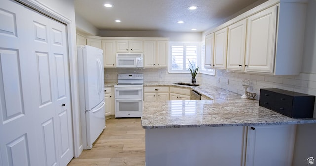 3139 N 800 E, North Ogden, UT 84414 - kitchen featuring white appliances, a peninsula, recessed lighting, light wood-type flooring, and backsplash
