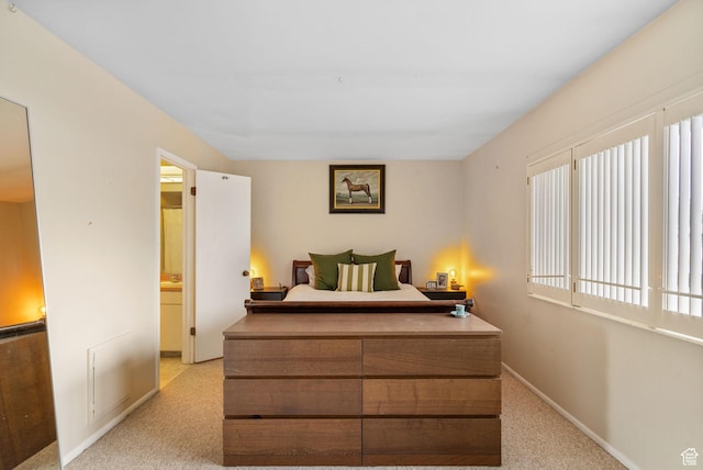 bedroom featuring light carpet and baseboards