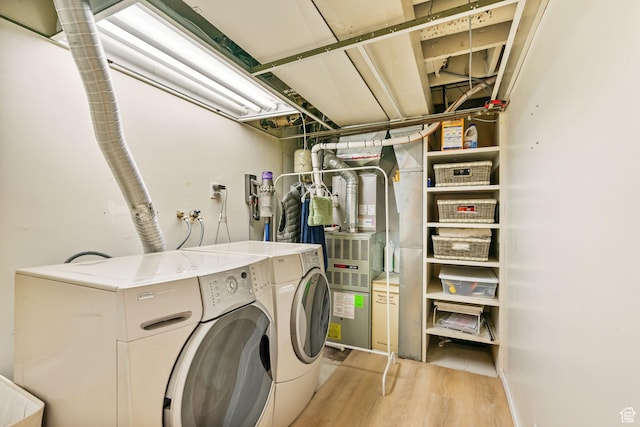 laundry area with washer and dryer and light wood finished floors