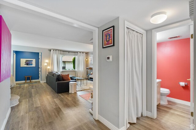 hallway with wood finished floors and baseboards