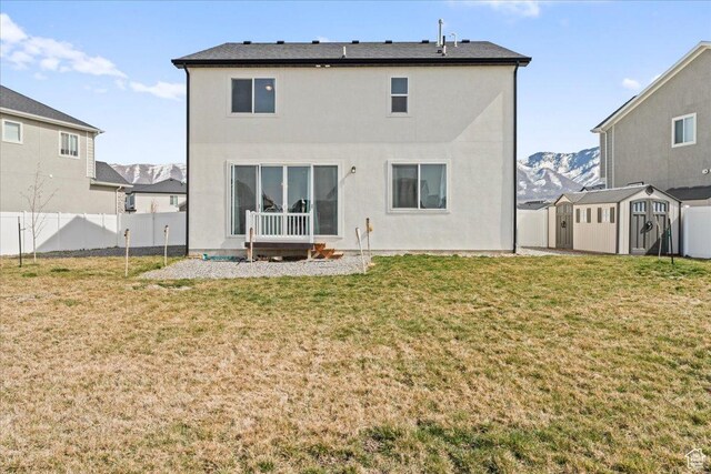 6405 N Appaloosa Dr, Stansbury Park, UT 84074 - back of property featuring a storage shed, an outbuilding, stucco siding, and a mountain view