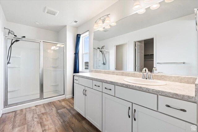 6405 N Appaloosa Dr, Stansbury Park, UT 84074 - full bathroom featuring a stall shower, wood finished floors, and vanity
