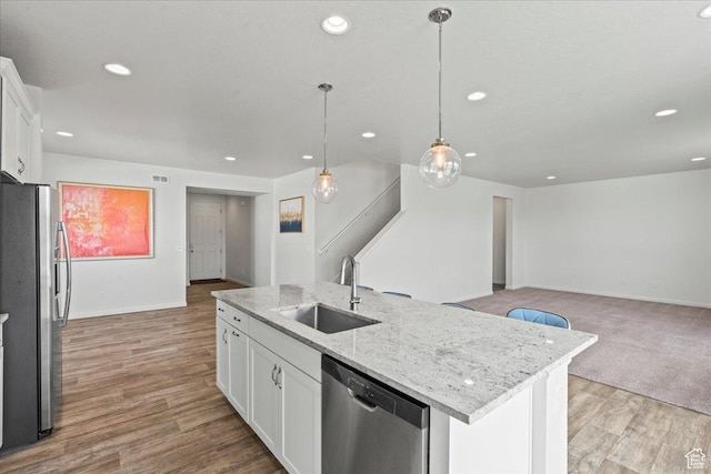 6405 N Appaloosa Dr, Stansbury Park, UT 84074 - kitchen featuring a sink, appliances with stainless steel finishes, open floor plan, white cabinets, and a center island with sink