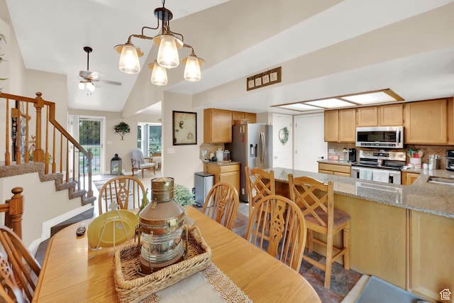 2298 W Jordan Meadows Cv, West Jordan, UT 84084 - dining space featuring a ceiling fan, stairway, and vaulted ceiling
