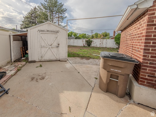 657 N Rambler Dr N, Salt Lake City, UT 84116 - view of patio featuring fence, a storage unit, and an outbuilding