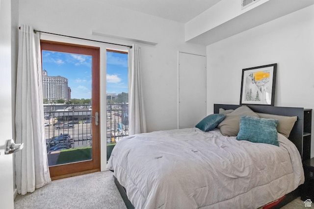 bedroom featuring access to exterior, a city view, and carpet flooring