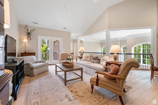 living room featuring light wood finished floors, ornate columns, high vaulted ceiling, and recessed lighting