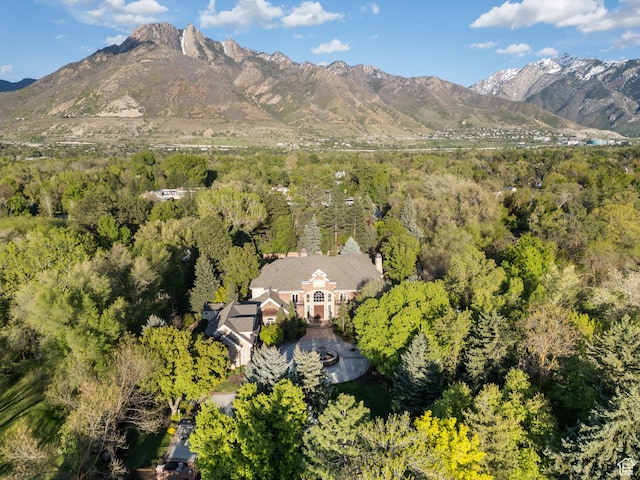 aerial view of property and surrounding area with a forest and a mountainous background