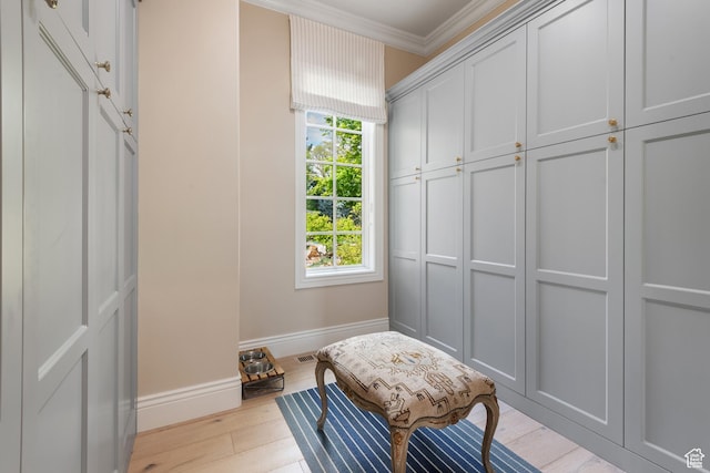 mudroom with crown molding, baseboards, and wood finished floors