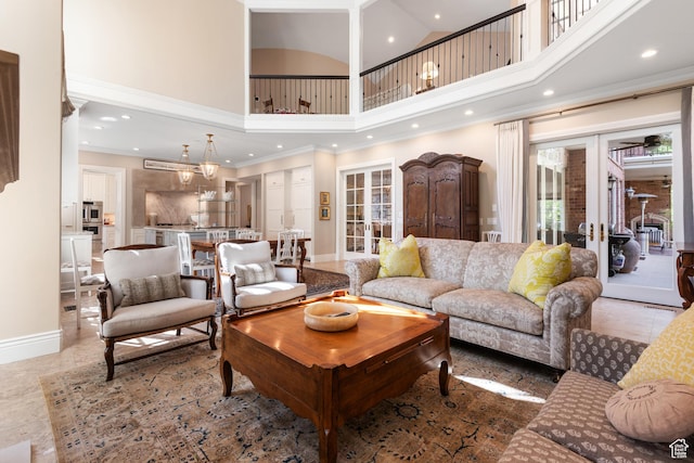 living area featuring a towering ceiling, recessed lighting, french doors, baseboards, and crown molding