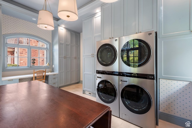 clothes washing area with estacked washer and dryer, cabinet space, and ornamental molding