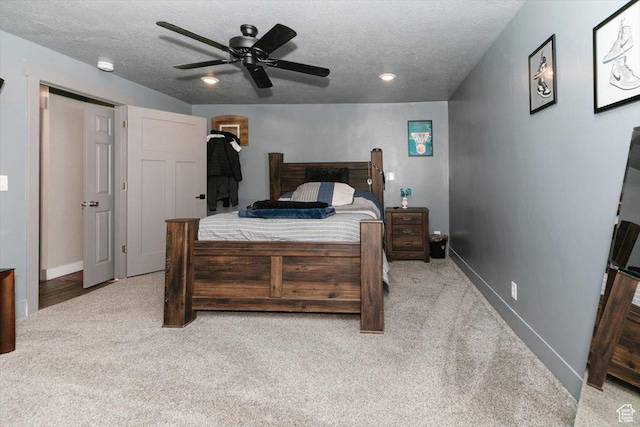 bedroom with carpet, baseboards, a textured ceiling, and ceiling fan
