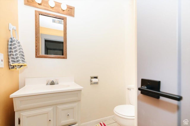 bathroom featuring vanity, toilet, tile patterned flooring, and baseboards