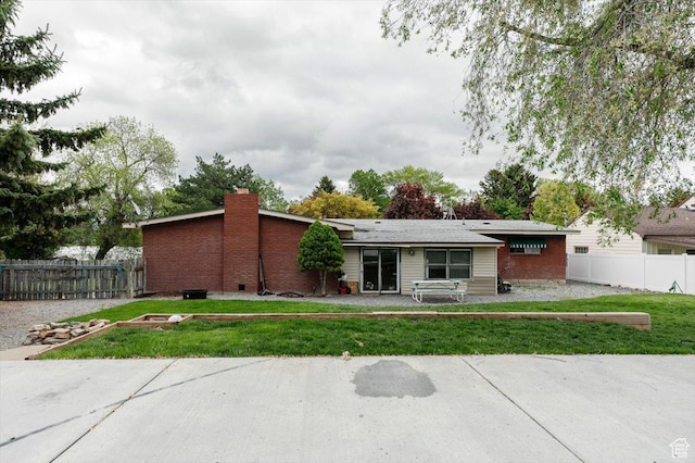 view of front facade featuring a chimney and brick siding
