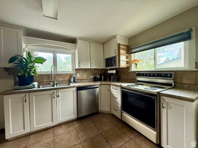 479 S Vernal Ave, Vernal, UT 84078 - kitchen with stainless steel appliances, a sink, backsplash, light tile patterned floors, and white cabinetry