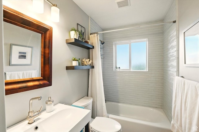bathroom featuring toilet, shower / bath combo with shower curtain, and vanity